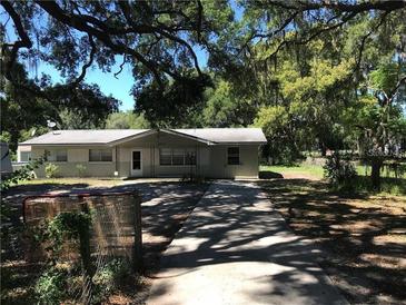 Charming single-story home with a long driveway and beautiful mature trees at 4922 Thonotosassa Rd, Plant City, FL 33565