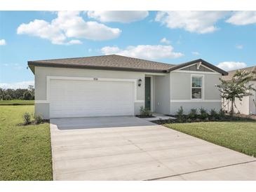Charming single-story home featuring a spacious driveway and manicured front lawn at 7728 Gilchrist Springs Dr, Parrish, FL 34219
