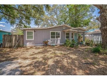 Charming single-story home featuring a well-maintained facade, a gravel yard and mature trees at 9307 N Oakleaf Ave, Tampa, FL 33612