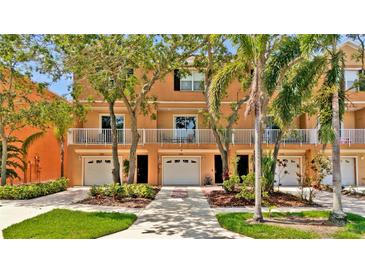 Inviting townhouse exterior with a white fenced balcony, a one car garage and neat landscaping at 5016 W Lancaster St # 00, Tampa, FL 33616
