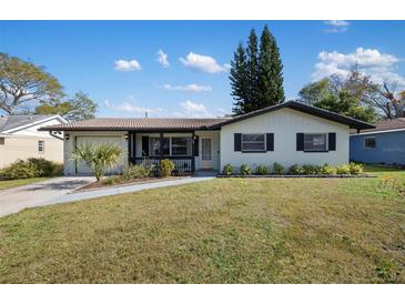 Charming single-story home with well-maintained lawn and inviting front porch at 1073 Kenwood Dr, Dunedin, FL 34698