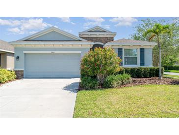 Charming single-story home with a well-manicured lawn, two-car garage, and appealing landscaping at 7308 Hermes Ct, Apollo Beach, FL 33572