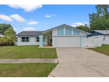 Charming single-story home featuring a two-car garage, well-maintained lawn, and light blue accents at 14506 Sutter Pl, Tampa, FL 33625