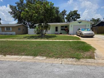 Charming single-story home with a well-maintained front yard and attached garage at 1079 Woodbrook S Dr, Largo, FL 33770