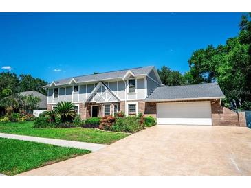Charming two-story home featuring a well-manicured front yard and attached two car garage at 3009 Ridgevale Cir, Valrico, FL 33596