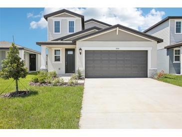 Charming two-story home featuring a modern exterior, well-manicured lawn, and a spacious driveway with an attached garage at 3550 Moscato Dr, Brooksville, FL 34602