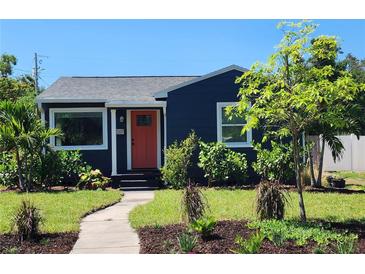 Charming home featuring a blue exterior, complemented by a well-maintained front yard and vibrant landscaping at 420 61St S Ave, St Petersburg, FL 33705