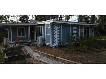 Quaint home featuring blue siding, lattice accents, and a charming garden bed, perfect for relaxed outdoor living at 6505 Oelsner St, New Port Richey, FL 34652