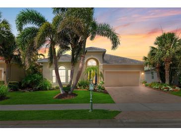 Charming single Gathering home featuring lush landscaping, manicured lawn, and a brick paver driveway at sunset at 13064 N Marsh Dr, Port Charlotte, FL 33953