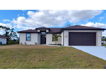 Charming single-story home with a two-car garage, manicured lawn, and a beautifully landscaped yard at 3269 Ponce De Leon Blvd, North Port, FL 34291