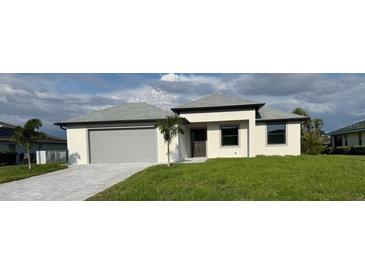 Beautiful single-story home featuring a gray roof, gray garage door and manicured lawn at 9 Bunker Pl, Rotonda West, FL 33947