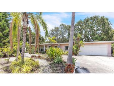 Charming home featuring lush tropical landscaping and a well-maintained two-car garage at 251 Tropic W Blvd, Largo, FL 33770