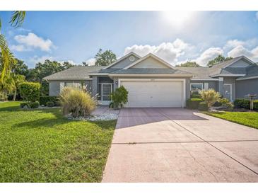 Charming single-story home featuring a well-manicured lawn and a two-car garage with ample parking space at 2015 Gardenia Landings Ln, Sun City Center, FL 33573