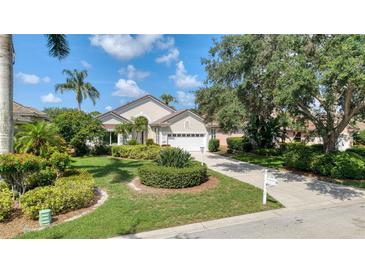 Charming single-Gathering home featuring lush landscaping, a well-manicured lawn, and a two-car garage at 6504 Virginia Xing, University Park, FL 34201