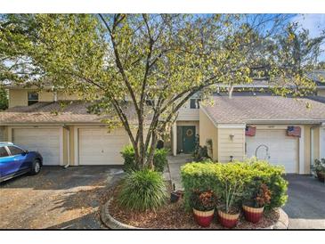 Charming townhome with well-manicured landscaping and attached garage, perfect for suburban living at 11239 Cedar Hollow Ln, Tampa, FL 33618