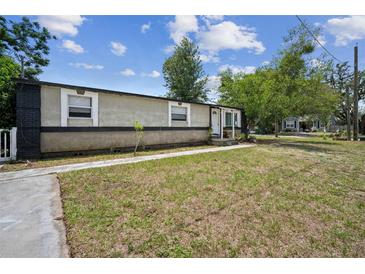 Charming home featuring a spacious front lawn and a covered entrance, creating a welcoming curb appeal at 1711 E Sewaha St, Tampa, FL 33612