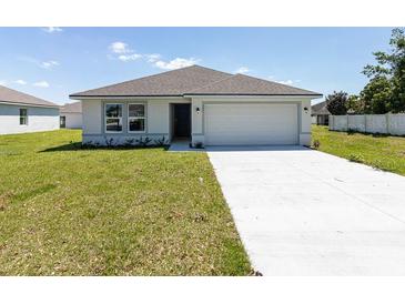 Charming single-story home with well-maintained lawn and two-car garage on a sunny day at 23461 Wickens Ave, Port Charlotte, FL 33980