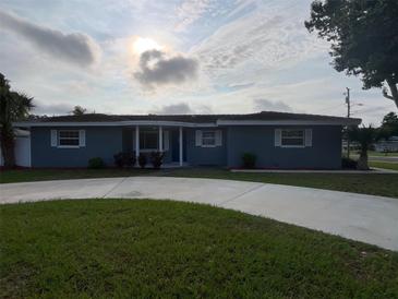 Charming single-story home with a well-manicured lawn, circular driveway, and inviting front entrance at 1035 S Duncan Ave, Clearwater, FL 33756
