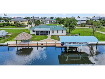 Waterfront home with lush landscaping, private dock, tiki hut and boat lift at 24277 Treasure Island Blvd, Punta Gorda, FL 33955