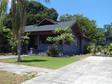 Charming blue bungalow featuring a well-manicured lawn and inviting curb appeal at 834 Jackson N St, St Petersburg, FL 33705