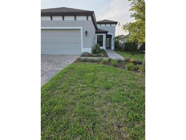 Charming single Gathering home featuring a well-manicured lawn and paver walkway at 12513 Oak Hill Way, Parrish, FL 34219