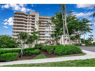 Stunning condominium exterior showcases lush landscaping and a beautiful, multi-story facade, with large windows at 3010 Grand Bay Blvd # 472, Longboat Key, FL 34228
