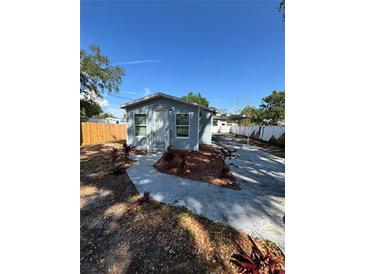 Charming, light blue single-story home featuring a well-maintained front yard and convenient carport at 5015 N 29Th St, Tampa, FL 33610