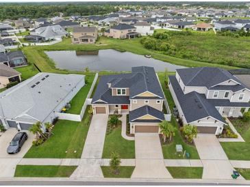 Expansive home features meticulous landscaping, a three-car garage, and a picturesque pond view at 7163 Talamore Dr, Wesley Chapel, FL 33545