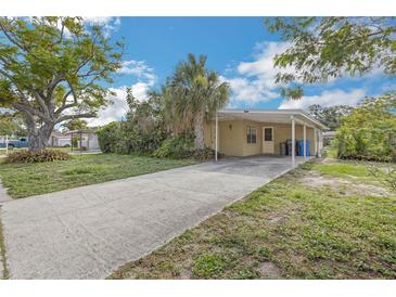 Charming single-story home with a covered carport, driveway, mature landscaping and a welcoming facade at 5101 Town N Country Blvd, Tampa, FL 33615