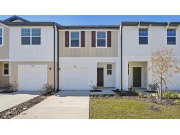 Modern townhouse exterior featuring attached garages, stylish facades, and well-kept landscaping at 6174 Daerr Ridge St, Zephyrhills, FL 33542