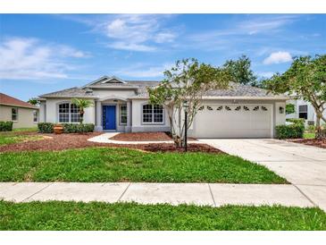 Charming single-story home with a manicured lawn, walkway, attached garage, and a striking blue front door at 11018 Pine Lilly Pl, Lakewood Ranch, FL 34202