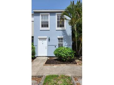 Charming light blue townhouse with white door, neat landscaping and beautiful mature palm trees at 6600 121St Ave # 5, Largo, FL 33773