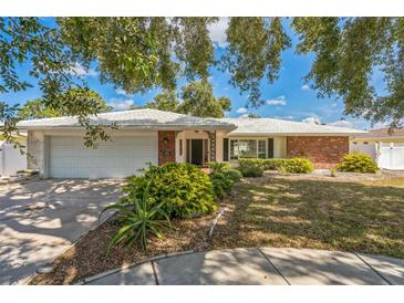 Charming single-story home with brick accents, manicured landscaping, and a two-car garage at 2521 Carlisle Pl, Sarasota, FL 34231