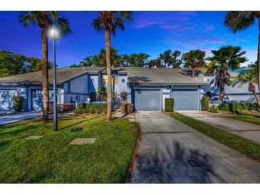 Inviting two-story townhome features a private driveway and a well-maintained front yard with lush landscaping at 4239 Brentwood Park Cir, Tampa, FL 33624
