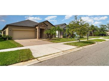 Charming single-story home featuring a brick-paved driveway and a well-manicured lawn at 13244 Satin Lily Dr, Riverview, FL 33579