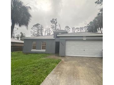 Exterior view of a single-story home with an attached garage, driveway, and lawn at 3805 N Cranberry Blvd, North Port, FL 34286