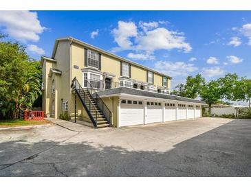Exterior shot of a three-story townhome with individual garages and outdoor stairwell at 609 S Glen Ave # E, Tampa, FL 33609
