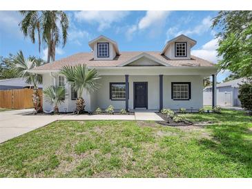 Charming home featuring a well-manicured lawn, complemented by mature palm trees and inviting curb appeal at 4413 W Wallcraft Ave, Tampa, FL 33611