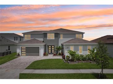 Beautiful two-story home showcasing a modern elevation, well-manicured lawn, and two-car garage at 9201 Sanders Tree Loop, Wesley Chapel, FL 33545