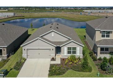 Charming single-Gathering home featuring a two-car garage, complemented by lush landscaping, and a serene water view at 17127 Harvest Moon Way, Bradenton, FL 34211