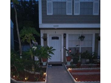 Charming home featuring a landscaped front yard with walkway, lighting, and updated windows and shutters at 6640 121St Ave # 1, Largo, FL 33773