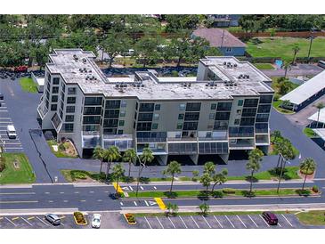Aerial view of a light beige condominium complex, highlighting the building's architecture and well-maintained surroundings at 9860 62Nd N Ter # 1047, St Petersburg, FL 33708