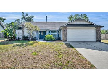 Charming home featuring a two-car garage, a lush front yard, and a welcoming blue entry door at 2601 Bridle Dr, Plant City, FL 33566
