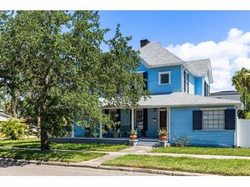 Charming two-story home with a covered front porch, mature tree, and well-maintained lawn at 8407 Interbay Blvd, Tampa, FL 33616