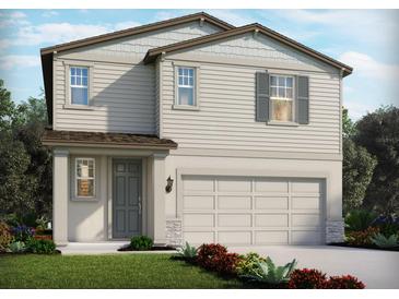 Charming two-story home with a two-car garage, landscaped yard, and stylish gray accents at 1844 Brekey Way, Zephyrhills, FL 33541