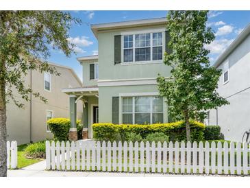 Charming two-story home with a picket fence and well-maintained landscaping in a suburban neighborhood at 11314 Grand Park Ave, Riverview, FL 33578