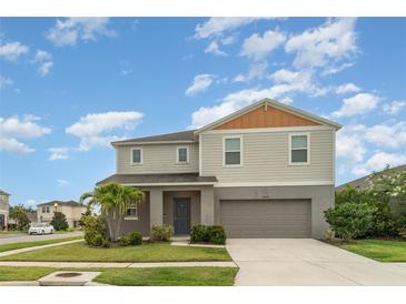 Two-story home featuring a two-car garage, landscaped lawn, and neutral-toned exterior with a welcoming entrance at 12829 Scarlet Star Dr, Riverview, FL 33579