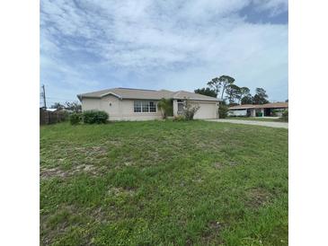 Charming single-story home with a well-maintained lawn and attached two car garage at 1140 Belmar Ave, Port Charlotte, FL 33948