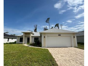 This beautiful single Gathering home features a 2-car garage, well manicured lawn and a concrete driveway at 16475 Hillsborough Blvd, Port Charlotte, FL 33954