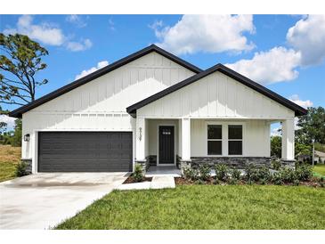 Charming single-story home featuring a modern design, a two-car garage, and a well-manicured lawn at 9739 Loretto St, Spring Hill, FL 34608